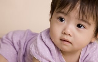 Closeup of baby in purple onesie.