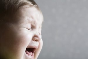Closeup of baby crying during bedtime battles.